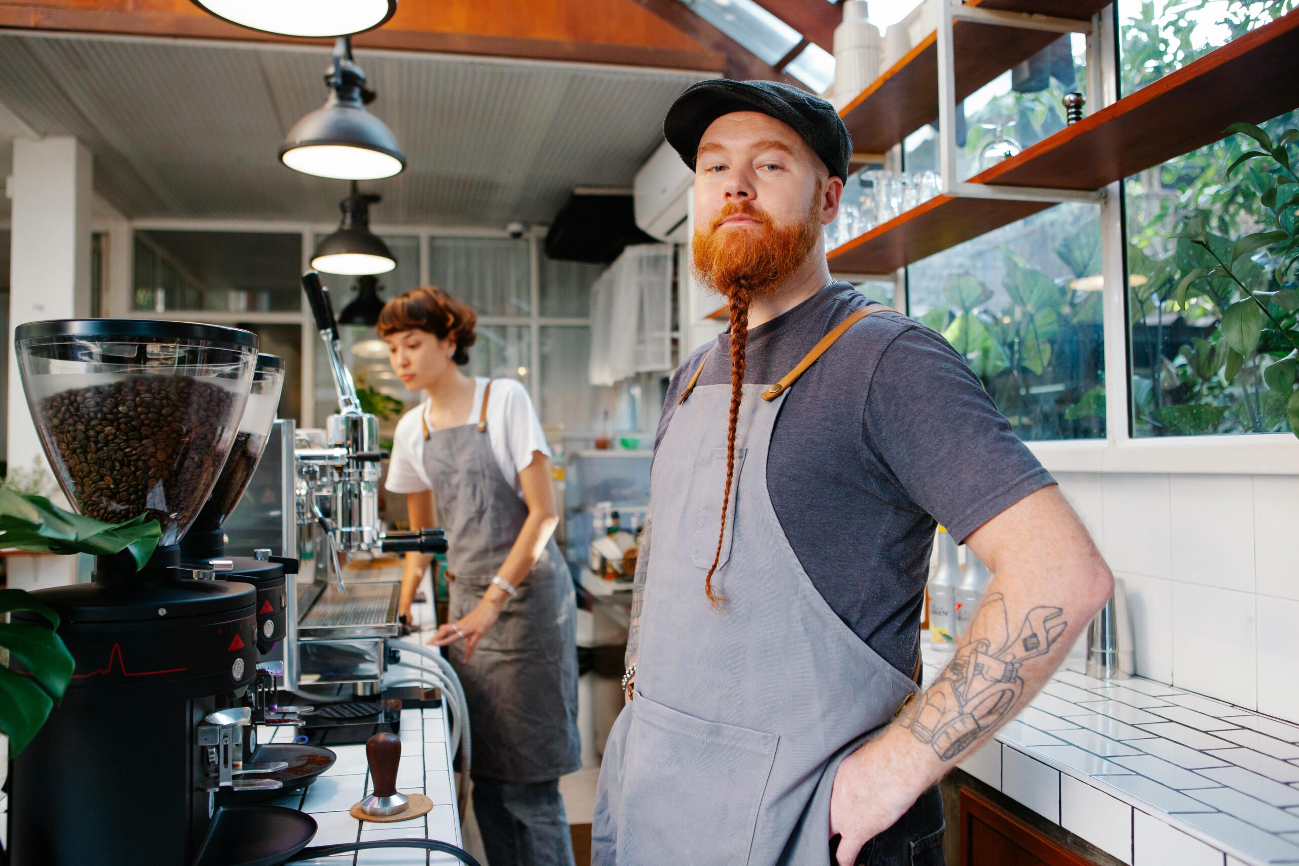 Barista team working with coffee equipment in a stylish, light-filled café. Focused on brewing excellence.